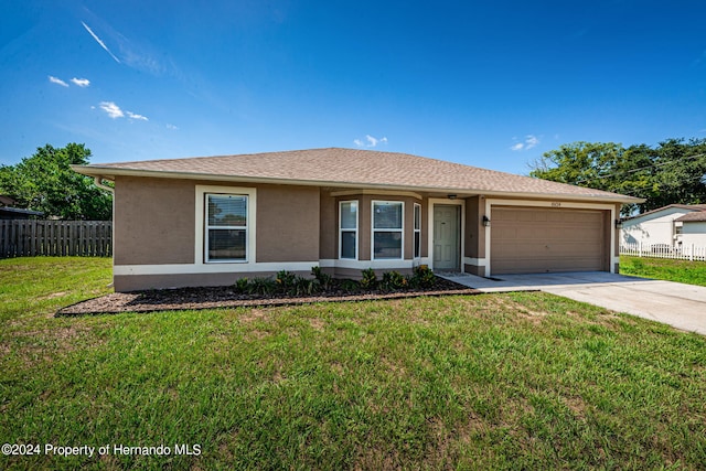 single story home with a garage and a front yard