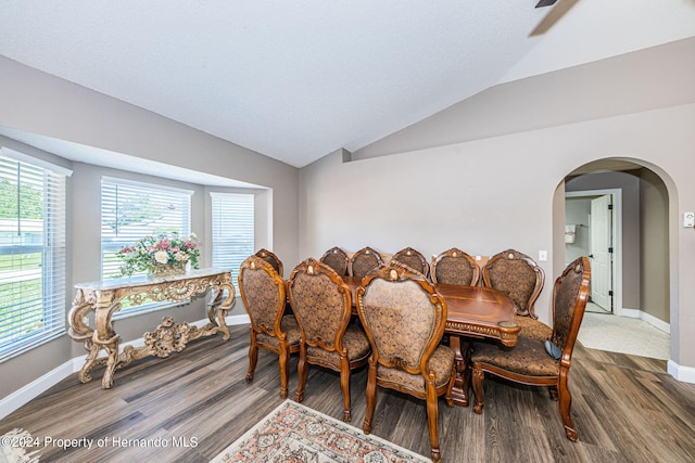 dining area featuring vaulted ceiling and wood-type flooring