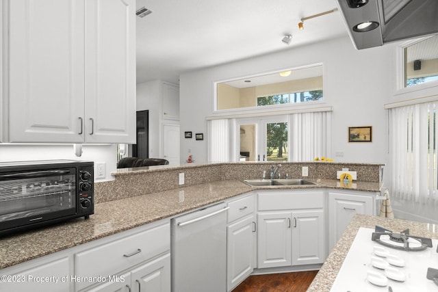 kitchen featuring stainless steel dishwasher, light stone countertops, white cabinetry, and sink