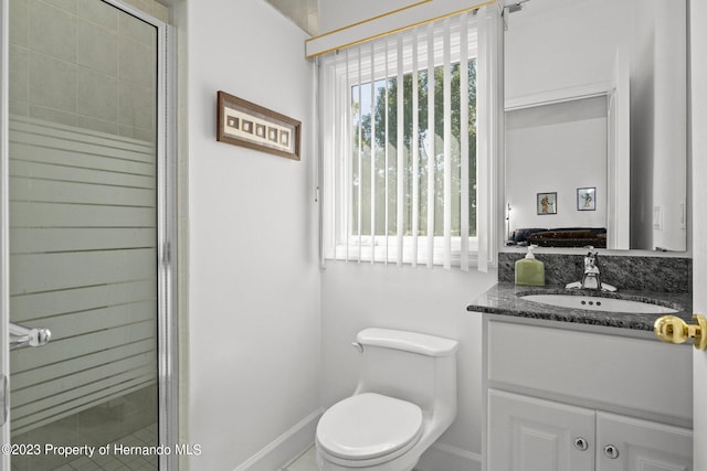 bathroom with an enclosed shower, vanity, and toilet