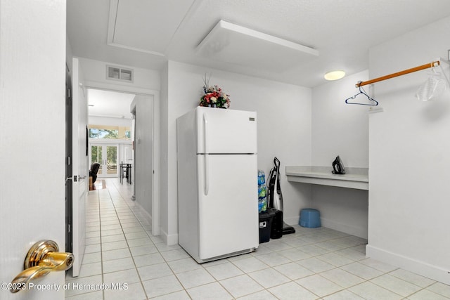 kitchen featuring light tile patterned floors and white fridge