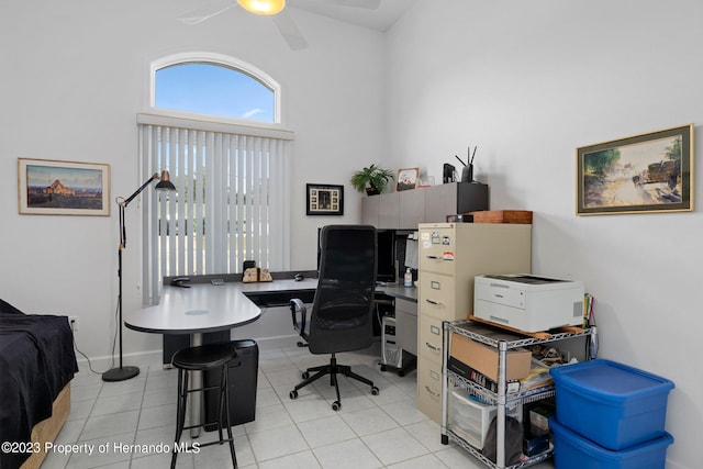 tiled office with ceiling fan and a high ceiling