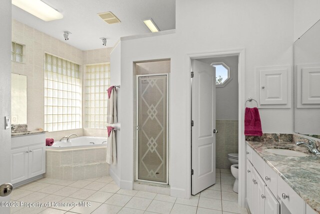 full bathroom featuring a bidet, toilet, tile patterned flooring, plus walk in shower, and vanity