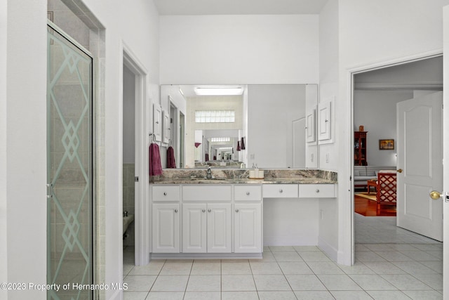 bathroom featuring tile patterned flooring, vanity, and a shower with shower door