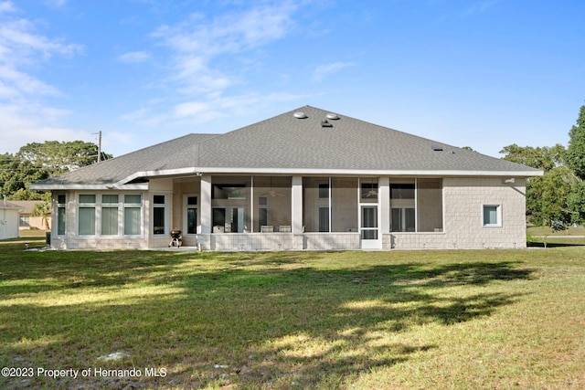 rear view of house featuring a sunroom and a yard