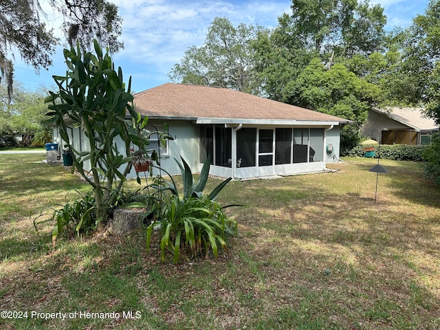 rear view of property with a sunroom and a yard