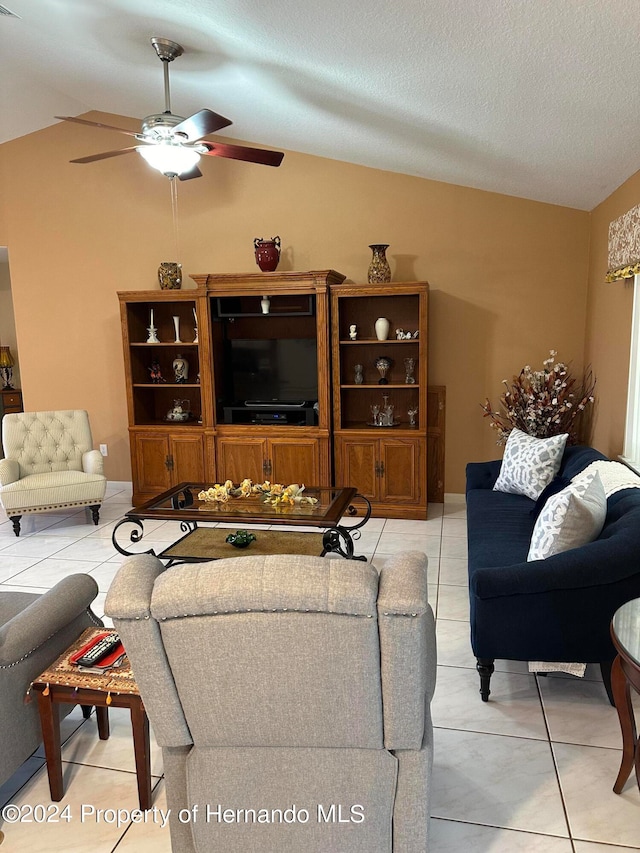 tiled living room featuring ceiling fan, a textured ceiling, and vaulted ceiling