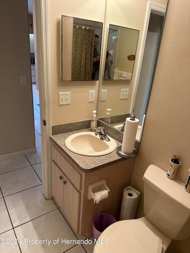 bathroom with tile patterned flooring, vanity, and toilet