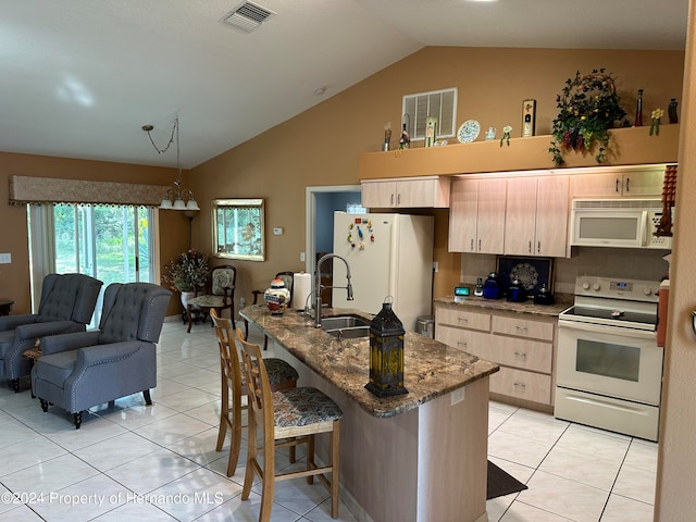 kitchen featuring sink, lofted ceiling, white appliances, light brown cabinetry, and light tile patterned floors