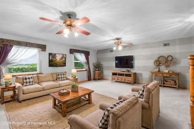 living room featuring light carpet, ceiling fan, visible vents, and baseboards