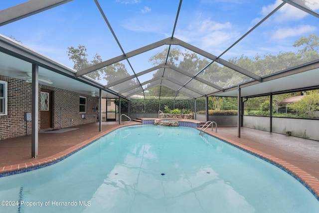 view of pool with ceiling fan, glass enclosure, a patio area, and a pool with connected hot tub