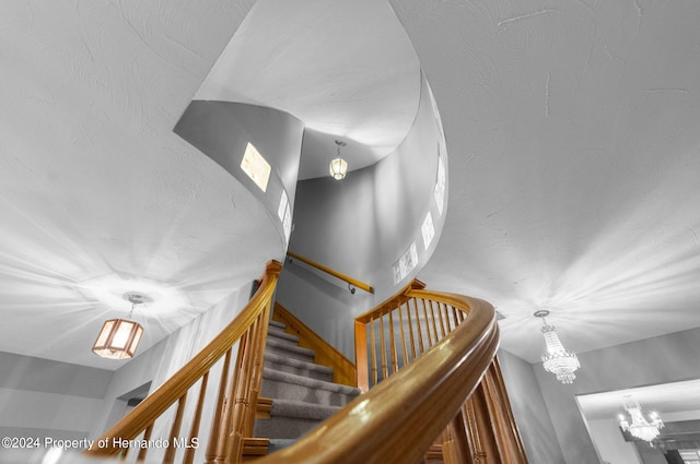 stairs featuring an inviting chandelier