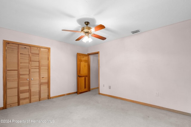 unfurnished bedroom with a closet, ceiling fan, and carpet floors