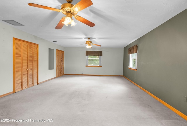 spare room with light colored carpet and ceiling fan