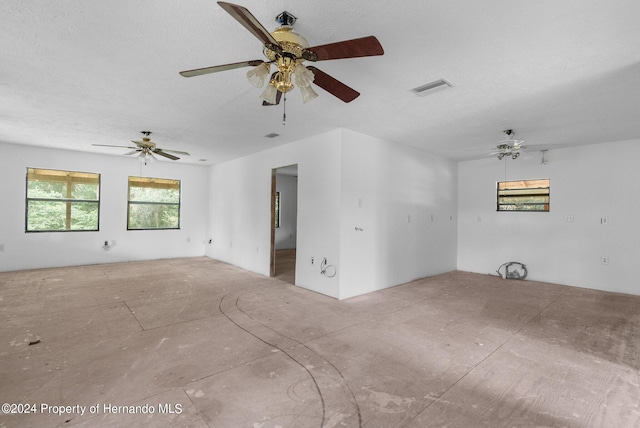 empty room featuring a ceiling fan, visible vents, and a textured ceiling