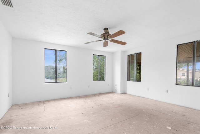 spare room featuring a textured ceiling, visible vents, and a ceiling fan