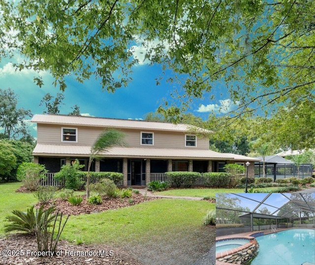 back of property featuring a pool with connected hot tub and a lawn