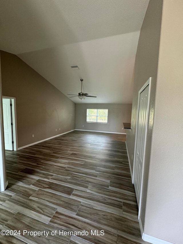 unfurnished living room with dark hardwood / wood-style floors, ceiling fan, and lofted ceiling