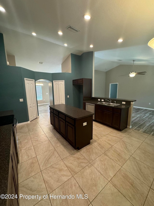 kitchen with ceiling fan, sink, lofted ceiling, dark brown cabinets, and a kitchen island