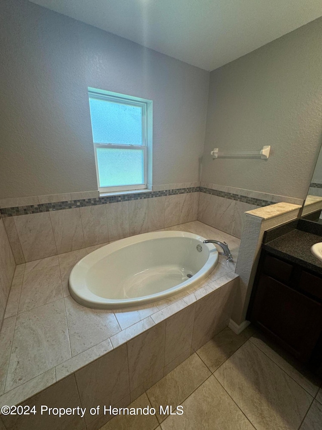 bathroom featuring vanity, tile patterned floors, and tiled tub