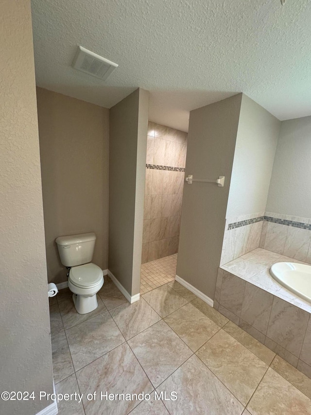 bathroom with separate shower and tub, tile patterned floors, a textured ceiling, and toilet