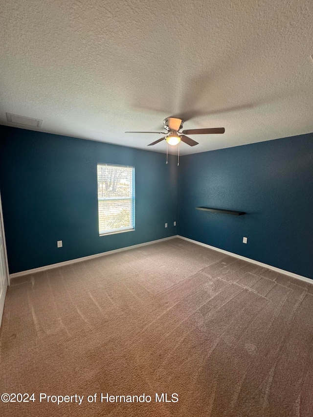 carpeted empty room featuring a textured ceiling and ceiling fan