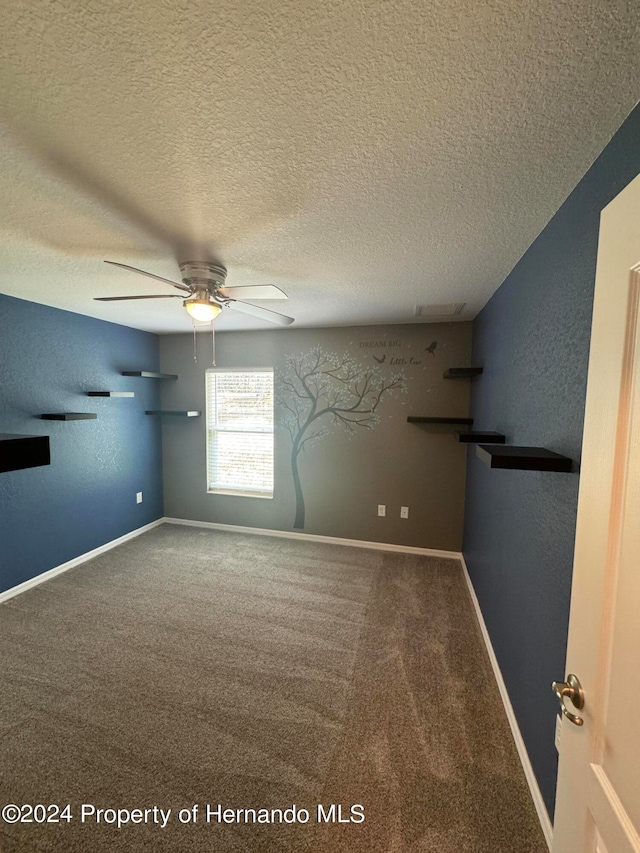 carpeted spare room with a textured ceiling and ceiling fan