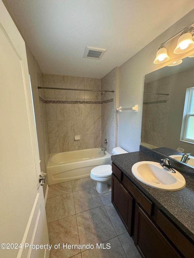 full bathroom with tile patterned floors, tiled shower / bath combo, toilet, and vanity