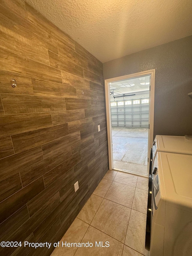 interior space with washing machine and clothes dryer, tile patterned flooring, and a textured ceiling