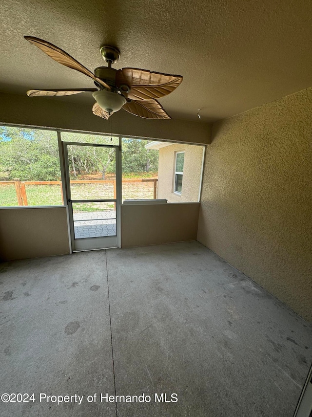 unfurnished sunroom with ceiling fan