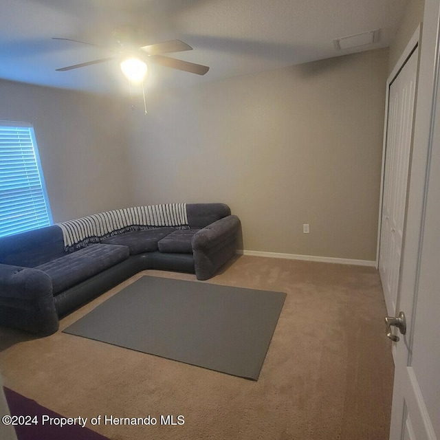 carpeted living room featuring ceiling fan