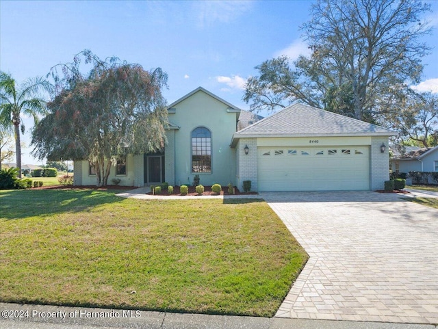 view of front of property with a garage and a front lawn