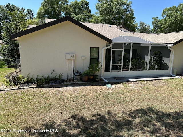 back of property featuring central air condition unit and a lawn