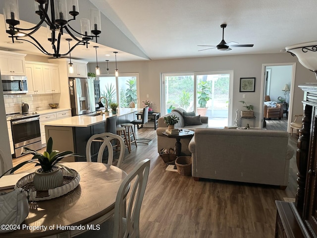 dining area with dark hardwood / wood-style floors, sink, and ceiling fan with notable chandelier