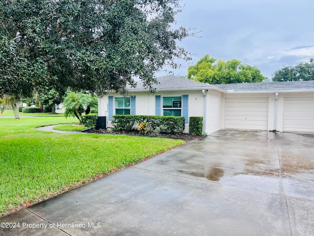 single story home featuring a garage, central AC, and a front yard