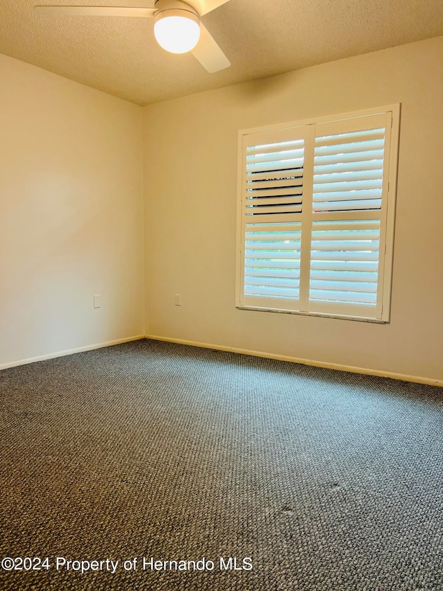 carpeted empty room featuring a textured ceiling and ceiling fan