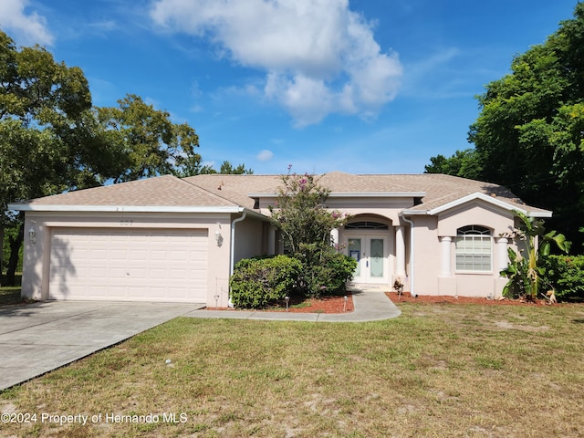 ranch-style home with a garage and a front lawn