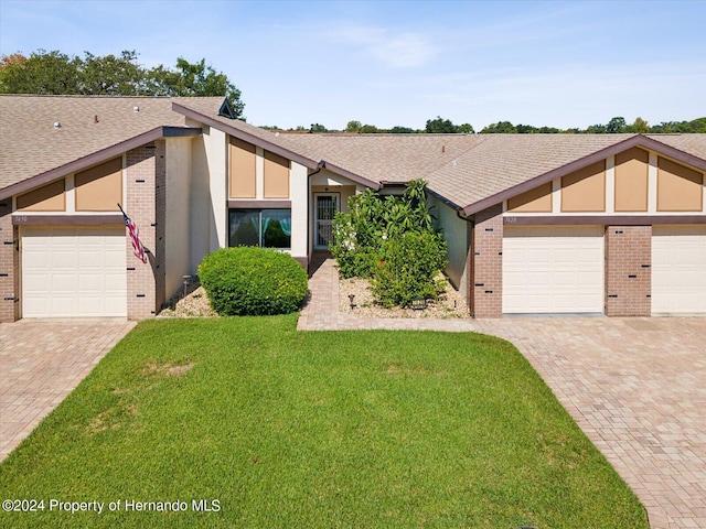 view of front of home with a garage and a front lawn