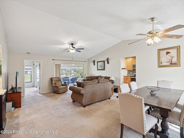 carpeted living room with ceiling fan, a textured ceiling, and vaulted ceiling