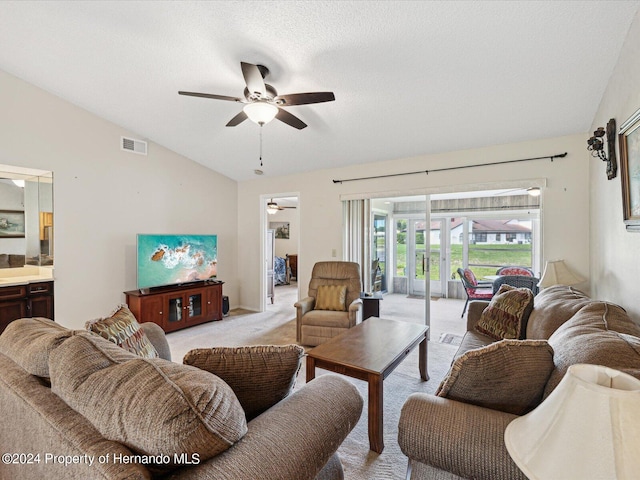 carpeted living room with a textured ceiling, ceiling fan, and vaulted ceiling