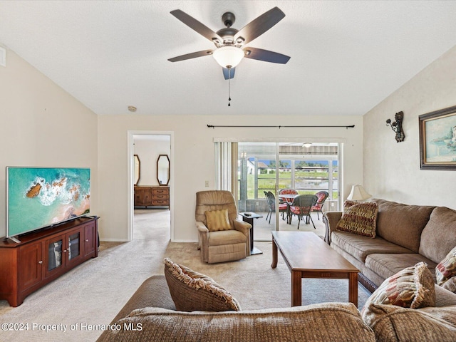 living room featuring vaulted ceiling, light carpet, ceiling fan, and a textured ceiling