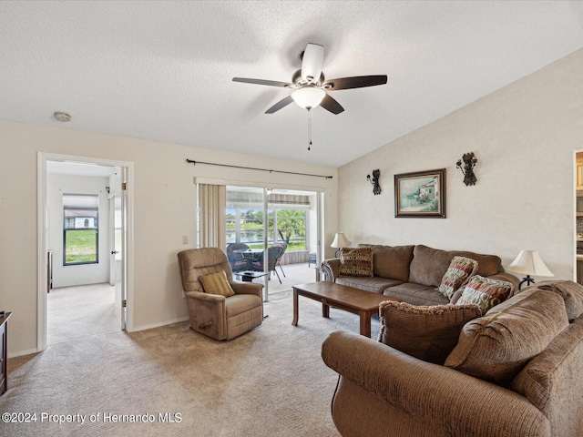 carpeted living room featuring a textured ceiling, ceiling fan, and vaulted ceiling