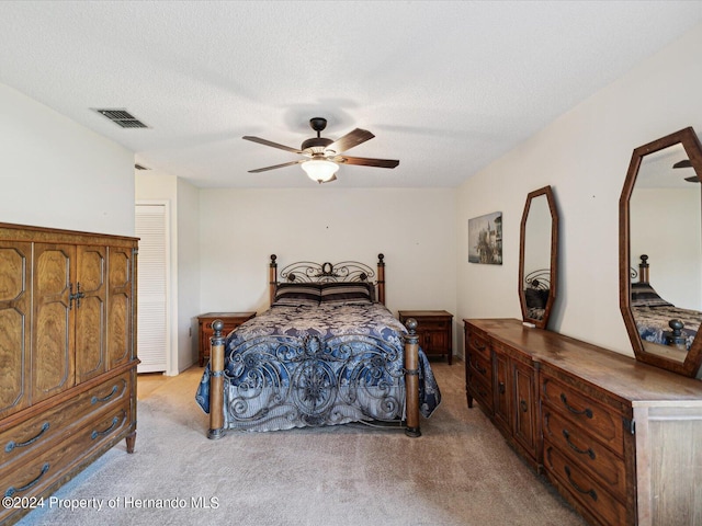 carpeted bedroom with a textured ceiling and ceiling fan