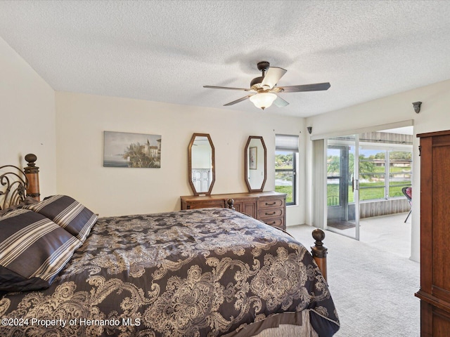 carpeted bedroom featuring a textured ceiling, ceiling fan, and access to exterior