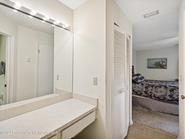 bathroom with vanity, tile patterned flooring, and a textured ceiling