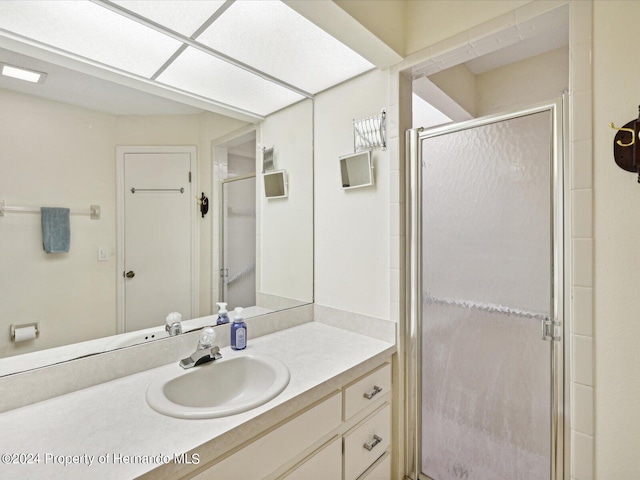 bathroom featuring vanity and a shower with door