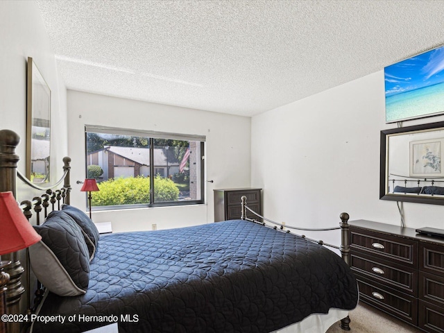 bedroom with a textured ceiling and light carpet