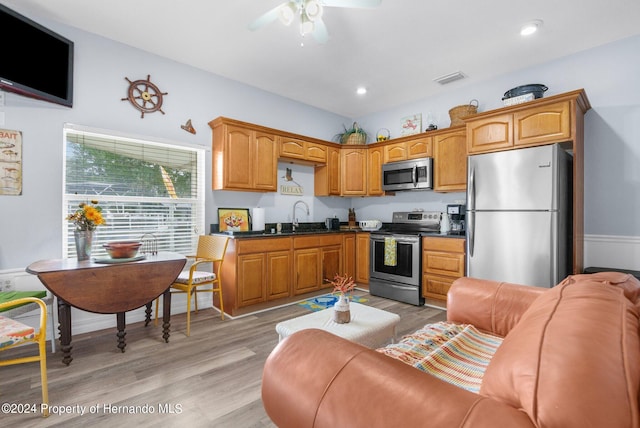 kitchen featuring ceiling fan, sink, light hardwood / wood-style floors, and stainless steel appliances