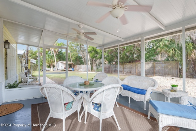 sunroom / solarium with lofted ceiling and ceiling fan