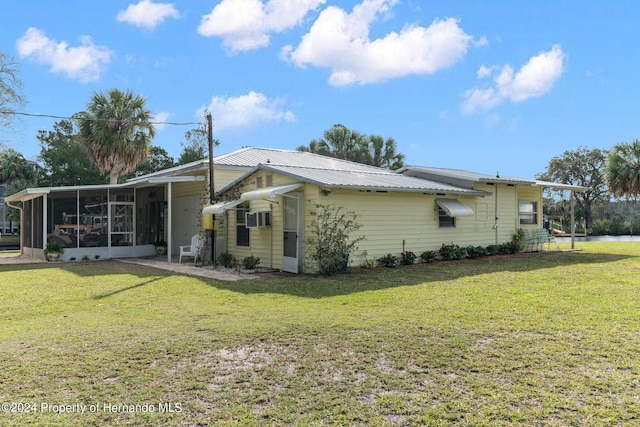 view of property exterior featuring a sunroom and a yard